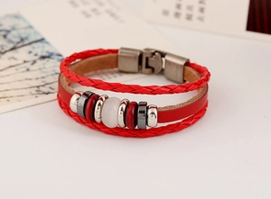 Dettaglio del bracciale multistrato in pelle rossa con perline di porcellana e chiusura