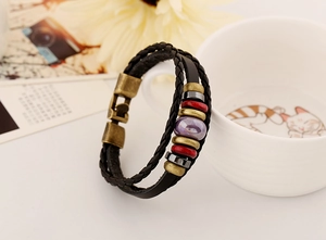 Close-up of vintage multilayer braided leather bracelet with ethnic beads and bronze clasp