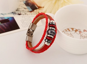 Dettaglio macro del bracciale in pelle rossa multistrato con perline e chiusura metallica
