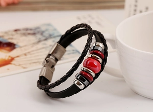 Detail of double-layer leather bracelet with red ceramic bead and vintage silver clasp