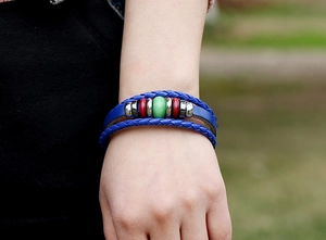 Detail of multi-layer blue leather woven bracelet with wooden beads on a wrist