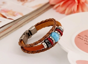 Detail of multi-layer braided leather bracelet with blue ceramic beads and metal clasp