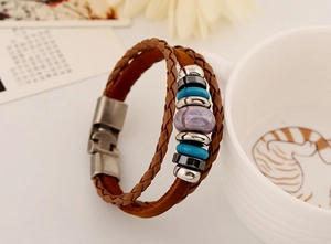 Détail d'un bracelet multicouche en cuir avec perles bleues sur une tasse en céramique