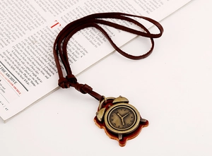 Macro view of vintage bronze alarm clock pendant on a dark brown leather cord