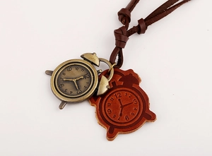 Close-up of vintage bronze alarm clock pendant and brown leather tag on a cord necklace