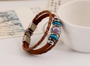 Détail d'un bracelet en cuir marron tissé à la main avec perles en céramique et fermoir