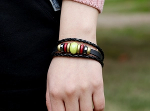 Détail d'un bracelet en cuir multicouche avec des perles en céramique colorées
