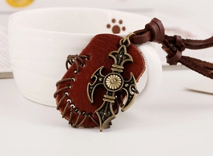 Detail of vintage bronze cross pendant with leather backing on white mug background