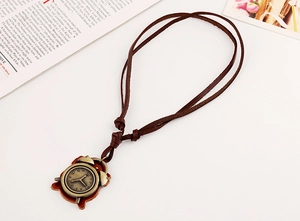 Detail of vintage bronze alarm clock pendant with brown leather backing and adjustable cord