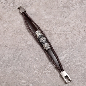 Macro detail of multilayer leather bracelet with cross beads and magnetic clasp