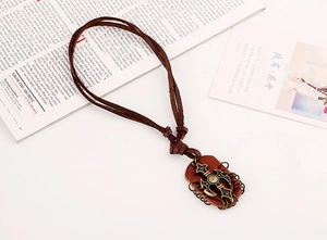 Detail view of punk leather necklace with cross pendant on artistic background
