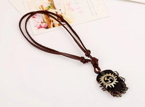 Detailed view of a vintage men's leather cord necklace with rustic metallic gear pendant