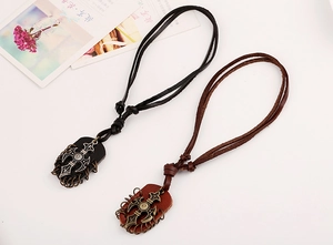 Macro detail of retro punk cross pendants on woven leather necklaces in black and brown