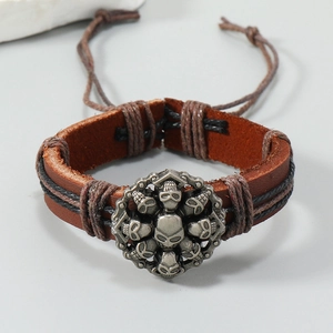 Gros plan du bracelet en cuir punk montrant le crâne argenté rétro et détails tressés