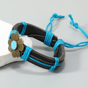 Gros plan du bracelet en cuir bohème avec cordon turquoise et fleur en métal vintage