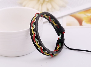 Détail d'un bracelet en cuir tressé rouge, jaune et vert sur une tasse blanche