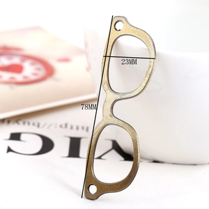 Close-up of vintage alloy eyeglass pendant leaning on a white ceramic cup for DIY jewelry