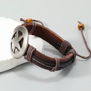 Detail of vintage brown leather bracelet with silver star charm on white stone