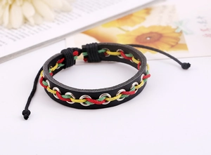Détail d'un bracelet en cuir tressé avec cordon rouge-jaune-vert et œillets