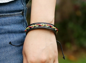 Détail du bracelet en cuir tressé avec cordons multicolores et œillets en métal