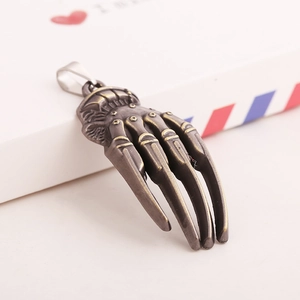 Retro punk style skeleton hand metal pendant with antique finish and embossed details