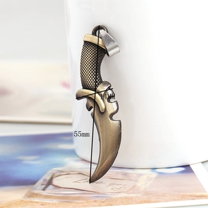Detail of vintage bronze curved dagger pendant showing 55mm size and grip texture