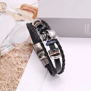 Close-up of multilayer leather bracelet with silver skull charm and metal clasp