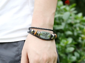 Macro detail of multilayer leather bracelet with beaded accents and skull metal plate