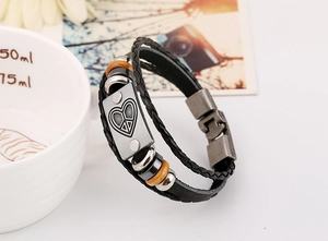 Detail view of multilayer leather bracelet with wooden beads and peace sign metal plate