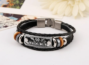 Détail du bracelet en cuir tressé avec breloques Curaçao et perles en bois naturel