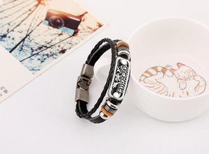 Détail de la plaque gravée Curaçao sur bracelet en cuir tressé noir à double couche