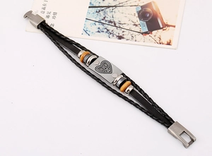 Detail of multilayer leather bracelet with wooden beads and peace heart metal charm