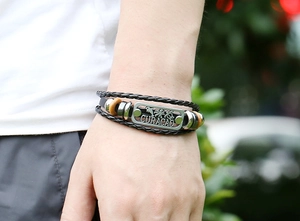 Détail macro du bracelet multicouche en cuir avec plaque métallique gravée Curacao
