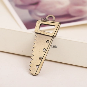 Detail view of a vintage bronze saw-shaped alloy charm with 52mm by 22mm dimensions