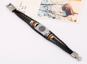 Detail of layered leather bracelet with silver peace symbol charm and wooden beads