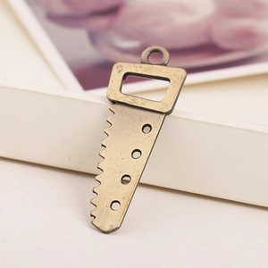 Vintage bronze alloy saw pendant with serrated edge and four circular decorative holes