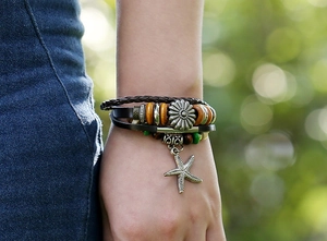 Detail of multi-layer leather bracelet featuring beads and a vintage starfish charm