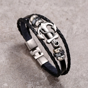 Detail of multi-layer leather bracelet featuring a silver anchor pendant and metal beads
