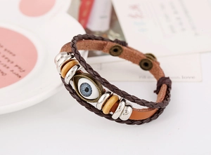 Detail of multi-layer leather bracelet with blue evil eye pendant and wooden beads
