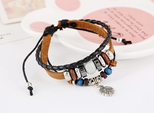 Détail d'un bracelet multicouche en cuir bohème avec pendentif feuille et perles bois