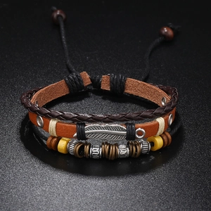 Close-up of multilayer leather bracelet with silver feather charm and wooden beads detail
