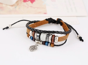 Gros plan du bracelet multicouche en cuir avec perles en bois et pendentif feuille