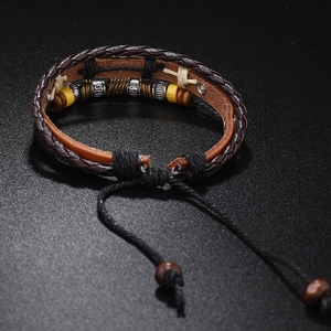 Detail of multi-layer braided leather bracelet with wooden beads and feather charm detail