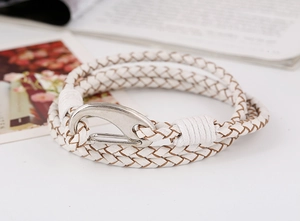 Macro detail of white braided leather bracelet featuring a large silver alloy hook clasp