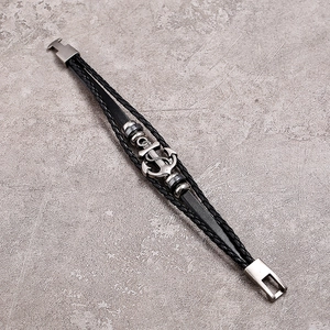 Detailed close-up of multilayer leather bracelet with silver anchor charm and clasp
