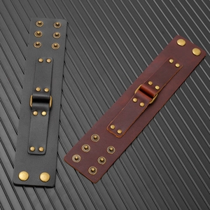 Close-up of black and brown leather punk bracelets with brass studs and metal rings
