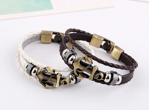 Detail of multi-layer leather bracelets with bronze anchor charms and metal clasps