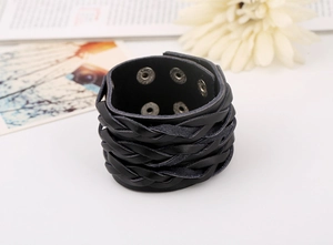 Close-up of black braided wide leather punk bracelet with silver metal snap buttons