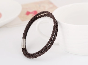 Detail of dark brown braided leather bracelet with silver magnetic metal clasp