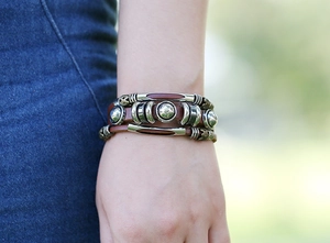 Close-up of a punk style multi-layer beaded leather bracelet worn on a wrist outdoors